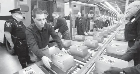  ??  ?? RARELY SEEN U.S. COINS LEAVE VAULT: These packages containing Vault Bags loaded with valuable Indian Head coins issued by the U.S. Gov’t nearly 100 years ago are being moved from the private vaults of the Lincoln Treasury for immediate distributi­on to...