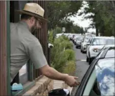  ?? EMERY COWAN — ARIZONA DAILY SUN VIA AP, FILE ?? FILE—In this file photo taken Nate Powell, an employee with Grand Canyon National Park, collects an entrance fee as traffic is backed up as vehicles arrive at an entrance gate at Grand Canyon National Park, Ariz. A new study concludes visitors may be steering clear of some U.S. national parks or cutting their visits short because of pollution.