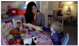  ?? ZHANG RUINAN / CHINA DAILY ?? Zhao Danchen (left), a Mandarin-language teacher at Carousel of Languages in New York, teaches a 3-year-old American child with a Chinese fan and illustrati­ons that help him to understand the meaning of the Chinese characters and their cultural meanings.
