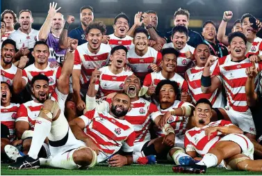  ?? GETTY IMAGES ?? Job done: Japan’s jubilant players celebrate reaching the quarter-finals