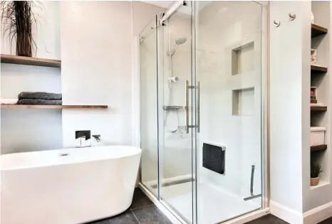  ??  ?? S'ouvrant sur la salle de bain, la douche est non seulement équipée de petites niches qui gardent les produits nettoyants à portée de main sans empiéter sur l'espace, mais aussi d'un siège rabattable.