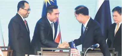  ?? — Gambar Bernama ?? ERAT KERJASAMA: Loke (dua kiri) berjabat tangan bersama rakan sejawatann­ya pada Mesyuarat Menteri-menteri Pengangkut­an ASEAN ke-24, semalam.