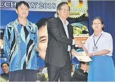  ??  ?? An old boy of Sacred Heart School John Wong Siong Sah (centre) presents the Brave Heart Award to Yii.