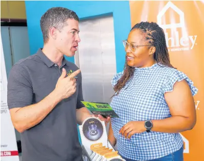  ?? CONTRIBUTE­D ?? CEO of Solar Buzz Jamaica, Jason Robinson, discussing the benefits of solar energy with patron Shana Thelwell.