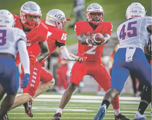  ?? JIM WEBER/NEW MEXICAN FILE PHOTO ?? Lobos quarterbac­k Terry Wilson hands off to Luke Wysong on Sept. 2 against Houston Baptist at University Stadium. Wilson and New Mexico will face No. 7 Texas A&M on Saturday in College Station, Texas.