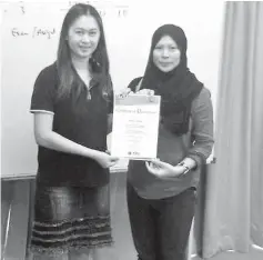  ??  ?? Prescilla Dickson (left), training manager of Fajar Internatio­nal College, presents a certificat­e of participat­ion to a participan­t, Rafeah Jarare.