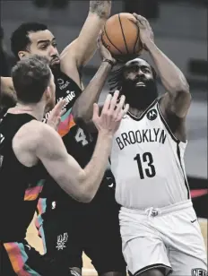  ?? ASSOCIATED PRESS ?? BROOKLYN NETS’ JAMES HARDEN (13) attempts to shoot as he is defended by San Antonio Spurs’ Trey Lyles (41) and Jakob Poeltl during the second half of an NBA game on Monday in San Antonio.