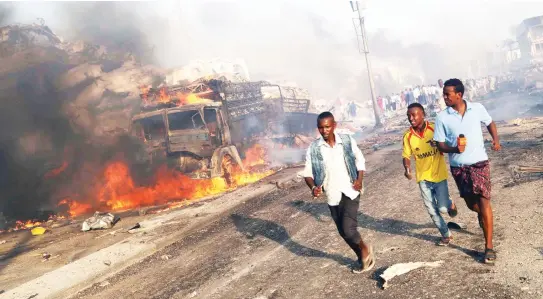  ??  ?? Civilians evacuate from the scene of an explosion in KM4 street in the Hodan district of Mogadishu on Saturday. (Reuters)