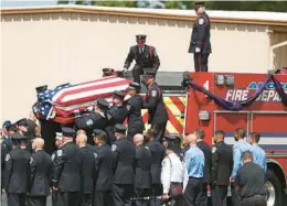  ?? STEPHEN M. DOWELL/ORLANDO SENTINEL ?? The body of firefighte­r Austin Duran is carried from the Loomis Funeral Home in Apopka to a waiting fire truck on July 23.