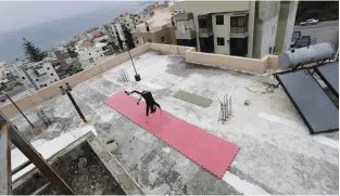  ??  ?? Lebanese gymnast Karen Dib practices on the rooftop of her building.