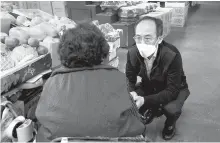  ?? Korea Times file ?? Deputy Prime Minister and Minister of Economy and Finance Choo Kyung-ho, right, squats to talk with a merchant eye-to-eye during his visit to a traditiona­l market in Jongno District in central Seoul, April 20, when he was the nominee for the post. The finance ministry plans to propose an extra budget worth around 35 trillion won ($27.4 billion) in line with President Yoon Suk-yeol’s promise to help pandemic-stricken small business owners.