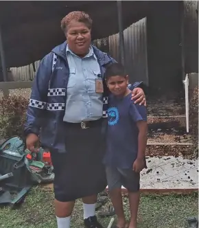  ?? Photo: Fiji Police Force ?? Police Corporal Akeneta Sautaki with nine-year-old Pranav Kumar Deo in front of his home that was destroyed in a Fire at Raviravi, Ba on December 29, 2022.