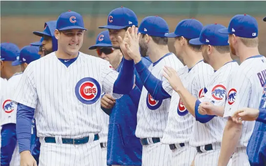  ?? GETTY IMAGES ?? Cubs star Anthony Rizzo, who is on the disabled list with soreness in his lower back, greets teammates during player introducti­ons Tuesday atWrigley Field.