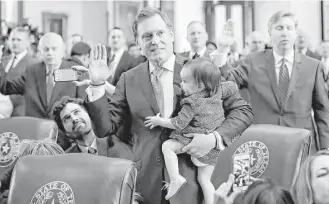  ?? Eric Gay / Associated Press ?? Rep. John Zerwas, R-Katy, holds his granddaugh­ter Tinley as he and other lawmakers are sworn in during the beginning of the 85th Texas legislativ­e session at the State Capitol on Tuesday.