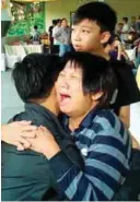  ??  ?? Relatives grieve as the caskets of their loved ones arrived at the funeral parlour in Batu Pahat.