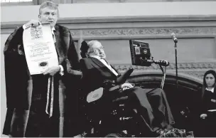  ?? MATT DUNHAM/ASSOCIATED PRESS FILE PHOTO ?? Britain’s Professor Stephen Hawking, right, is presented last year with an illuminate­d Freedom scroll by Chamberlai­n of the City of London Peter Kane, as he receives the Honorary Freedom of the City of London during a ceremony at the Guildhall....