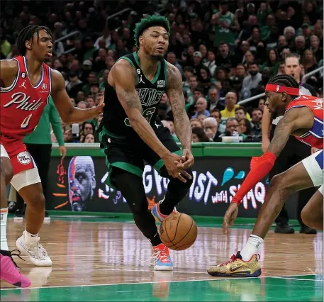  ?? MATT STONE/BOSTON HERALD) MAY 1, 2023 ?? Marcus Smart of the Boston Celtics looses the ball in between Tyrese Maxey #0 and Jalen McDaniels #7 of the Philadelph­ia 76ers during the second half of Game 1 of the NBA Eastern Conference Semifinals at the TD Garden on Monday in Boston, MA.