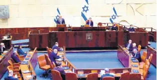  ?? AP ?? Benny Gantz (at podium), the centrist Blue and White party leader, and Israeli Prime Minister Benjamin Netanyahu’s partner in the new unity government, speaks during a swearing-in ceremony, at the Knesset, Israel’s parliament, in Jerusalem, yesterday.