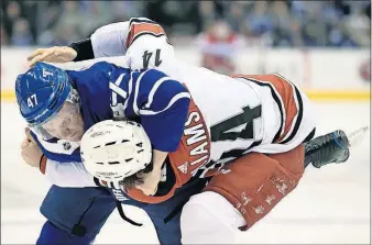  ?? [NATHAN DENETTE/THE CANADIAN PRESS VIA AP] ?? Toronto’s Leo Komarov, left, takes down Carolina’s Justin Williams during Tuesday’s game. RANGERS 4, DUCKS 1: RED WINGS 6, ISLANDERS 3: