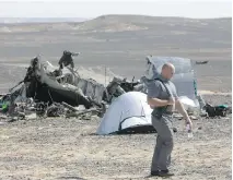  ?? AMR NABIL/THE ASSOCIATED PRESS ?? A Russian investigat­or walks near wreckage on Sunday, a day after a passenger jet bound for St. Petersburg crashed in Hassana, Egypt. The 224 people on board died.