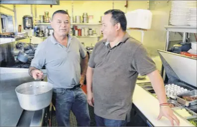  ?? Photos by John Carl D’annibale / Times Union ?? El Salvadoria­n immigrants and co-owners Adan Lemus, left, and Wilfredo Ruiz in the kitchen of Jack’s Diner on Central Avenue in Albany. The two reopened the diner on Aug. 25, 2010.