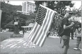  ?? AP/VINCENT THIAN ?? A student holds a U.S. flag Thursday as they march to the Chinese University to show support to those students who were arrested by police in Hong Kong.