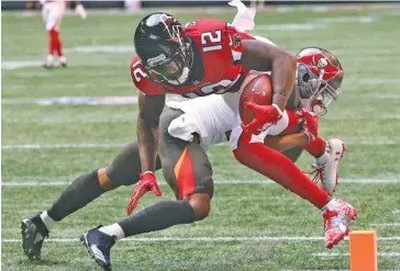  ?? AP PHOTO/CURTIS COMPTON ?? Atlanta Falcons wide receiver Mohamed Sanu dives into the end zone past Tampa Bay Buccaneers safety Justin Evans for a 35-yard touchdown catch during the first quarter of Sunday’s NFC South game in Atlanta. Sanu finished with two catches for 46 yards, and the Falcons won 34-29 to end their losing streak at three games.