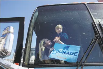  ?? Lea Suzuki / The Chronicle ?? Jennifer Siebel Newsom (left) holds hers and Lt. Gov. Gavin Newsom's son Dutch, 2, as he waves from the front of the bus at the opening of Newsom’s statewide campaign bus tour.