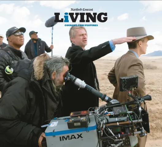  ?? UNIVERSAL PICTURES ?? Director Christophe­r Nolan, center, and actor Cillian Murphy, right, stand on the “Oppenheime­r” set as a crew member works with an IMAX camera in the foreground.