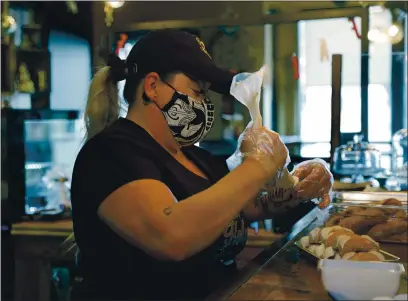  ?? NHAT V. MEYER — STAFF PHOTOGRAPH­ER ?? Jamie Whitmire fills a cannoli at her new Holy Cannoli! cafe and bakery in downtown San Jose. Specialty cannoli flavors include Nutella with hazelnuts, Grand Marnier with candied orange, Kahlua with espresso beans and Limoncello with white chips.