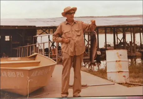  ?? Courtesy photo/JOY LONG ?? The late Dr. Ross Bizzell, father of fish-story champion Joy Long of Fayettevil­le, shows a catfish he caught.