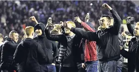  ??  ?? Wigan Athletic fans celebrate at the end of their English FA Cup fifth-round match against Manchester City at The DW Stadium, Wigan, England, yesterday. Wigan Athletic won the game 1-0.