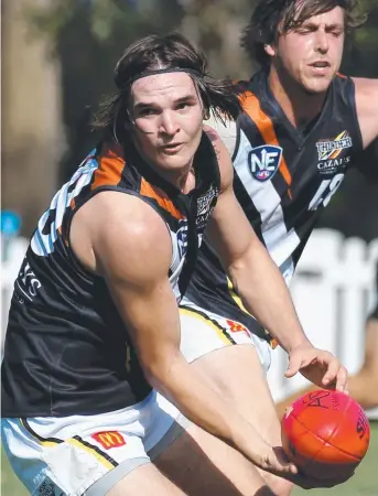  ?? Picture: STEVE POHLNER ?? Thomas Davies looks to handpass for NT Thunder during NEAFL action against Redland at Victoria Point yesterday in Brisbane as teammate Lachlan Collihole arrives to help