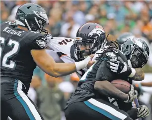  ?? ASSOCIATED PRESS FILE PHOTO ?? Philadelph­ia Eagles’ Jay Ajayi, right, tries to slip past Denver Broncos’ Domata Peko, center, with help from Jason Kelce during the first half of a Nov. 5 game in Philadelph­ia. Peko had no idea when he left Cincinnati for Denver in free agency this...