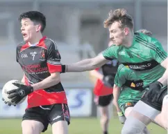  ??  ?? Getting the arm in: James Kelly is hounded by Tiernan Mackle