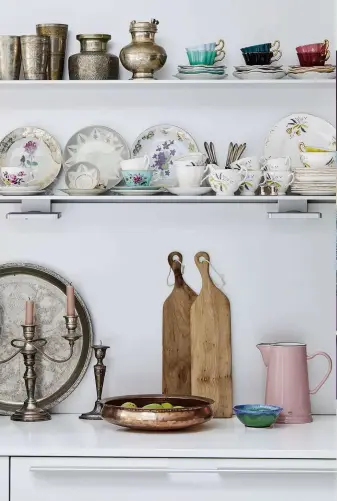  ??  ?? ABOVE Majeda had two shelves put along the kitchen wall for displaying her collection of antique and vintage china and Indian silverware. Many of these items were inherited from family members, but she has also added to the collection­s herself.