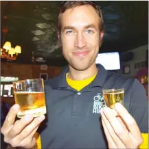  ?? Photos by Steve MacNaull ?? Bobby’s Chicago Bike Hike guide Gabe Fries psyches himself for the Chicago Handshake, the city’s signature drink of ghastly Malort liqueur, right, with a beer chaser.