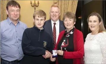  ??  ?? David Kelly, joint winner of the Tony Boland Award for best results, receives his award from Margaret Boland. Also pictured are Liam and Stephanie Kelly, and school principal Michael McMahon (centre).