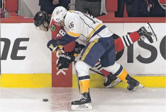  ??  ?? Predators center Craig Smith and Patrick Kane skate in close quarters along the boards. “I haven’t scored a goal in two games — not acceptable,” Kane said. | DAVID BANKS/ AP