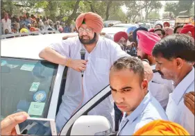  ??  ?? Amarinder Singh waves to the crowd as his cavalcade passes through Patiala’s roads. IANS