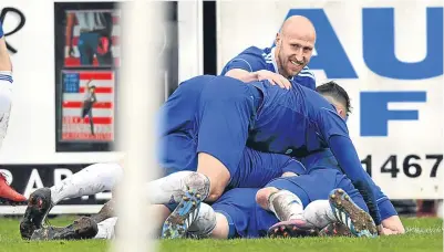  ??  ?? Pile-up: Eric Watson is at the bottom of the Cove pile as he celebrates his goal against Spartans