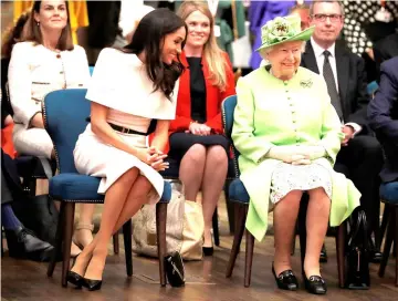  ?? — AFP file photo ?? Queen Elizabeth and Meghan gesture during their visit to the Storyhouse in Chester, Cheshire in June.