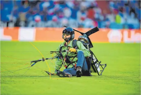  ?? FOTO: MATTHIAS HANGST/DPA ?? Der Greenpeace-Aktivist landete vor dem Spiel zwischen Deutschlan­d und Frankreich unsanft mit seinem Gleitschir­m auf dem Rasen.