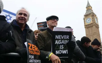  ?? (Susannah Ireland/Reuters) ?? DEMONSTRAT­ORS HOLD placards at a march against antisemiti­sm, in November in London. The writer asks: Why should we fight to remain in societies that at worst seem hostile to us and at best seem indifferen­t?