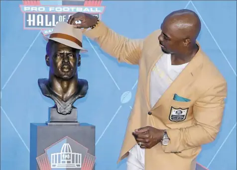  ?? Associated Press ?? New inductees have kissed, hugged and posed with their busts. But Brian Dawkins, one of eight members of the Class of 2018 to enter the Pro Football Hall of Fame Saturday, might be the first to see what his bust looks like wearing a hat.