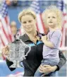  ?? — AFP ?? Kim Clijsters of Belgium carrying her daughter Jada after beating Vera Zvonareva of Russia to win the women’s final at the US Open 2010 in New York.