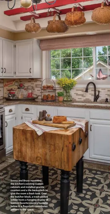  ??  ?? Sonna and Bruce repainted the kitchen’s existing custom cabinets and installed granite counters and a tile backsplash to give the room a fresh look. Over the butcher block, a trash-picked ladder hosts a hanging display of Sonna’s favorite country baskets; below it, a floorcloth contribute­s pattern to the space.