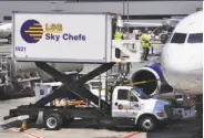  ?? Robert Alexander / Archive Photos/Getty Images ?? Workers for LSG Sky Chefs load a plane at SFO, where the union says they are owed money.