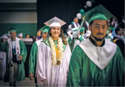  ?? PHOTOS BY RHONDA EVENHUS ?? Eli Sanchez and Lorena Velasquez enter the gym at Pojoaque Valley High School during their graduation ceremony.