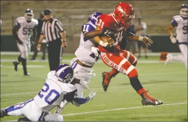  ?? DAVID WITTE/NEWS-SENTINEL ?? Lodi running back Alfredo Estrada hurdles his way through the defense of Bear Creek's Ethan George (20) and Michael Jones (11) during Lodi's victory on Sept. 29 at the Grape Bowl.